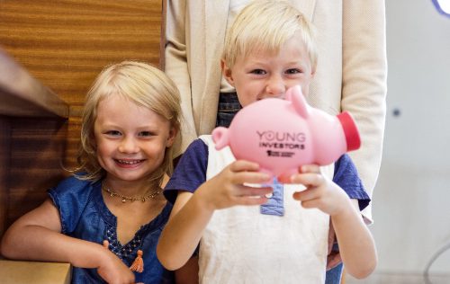 Two children holding a piggy bank